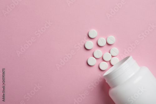 Bottle with pills on color background, flat lay. Space for text photo