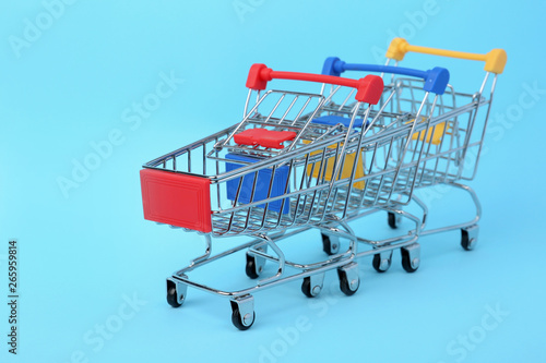 Empty shopping trolleys on color background. Space for text