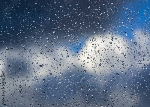 Water drops background. Water drops on glass window over blue sky