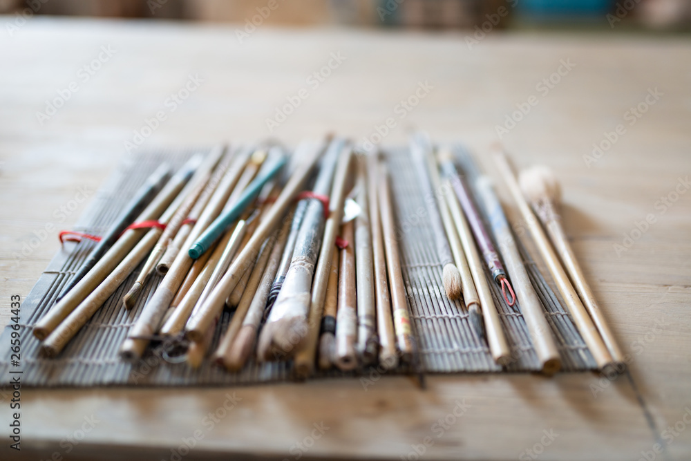 Closeup of a fountain pens and brushes on the table in pottery workshop Closeup of a fountain pens and brushes on the table in pottery workshop