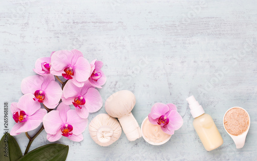 Sea salt  aromatherapy oil in bottles and orchid on vintage wooden background.