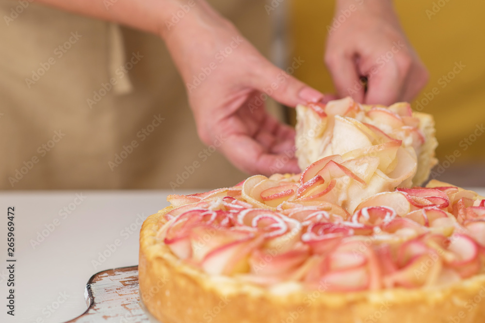 Woman cuts homemade apple cake, close-up. Pieces apple cake on a white wooden table. Delicious dessert. Tasty breakfast.