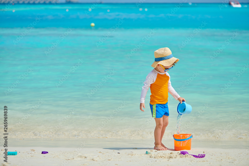 Three year old toddler playing on beach Three year old toddler playing on beach