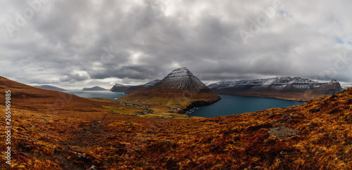 Panoramic view from Kap Enniberg to the small village Viðareiði, its fjords, Kunoy island and snow-covered mountains (Faroe Islands, Denmark, Europe) photo