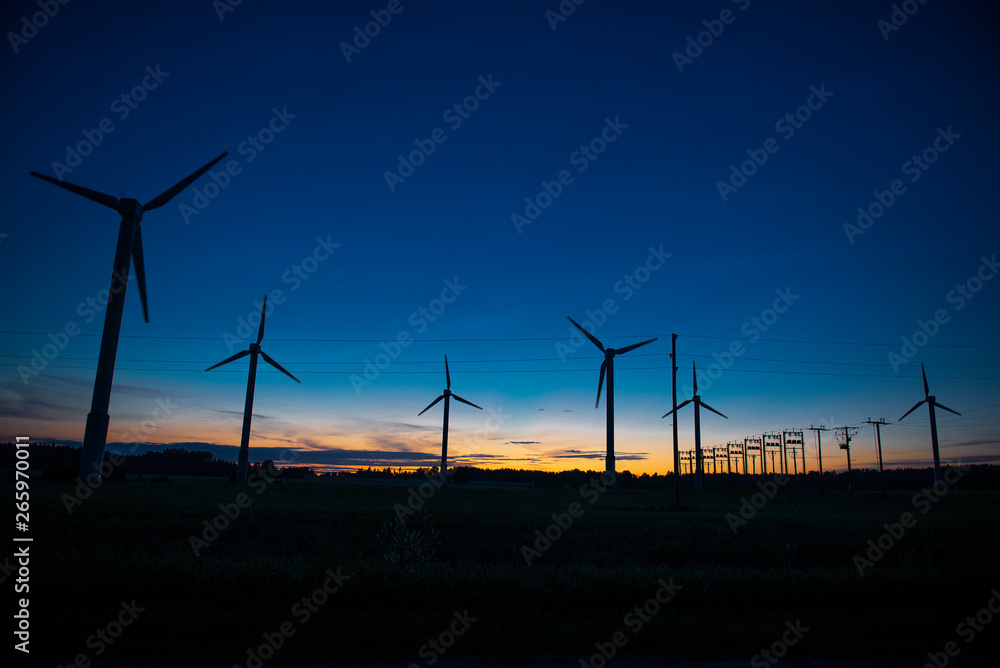 Obraz premium Power generators of windmills at shadow sunset - Wind turbine on field at sunset