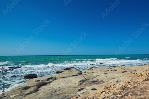 Summer landscape. Rocky coastline with a cove and rock  split view above water surface  Mediterranean sea  Spain. Azure sea  wave and blue sky. Seascape with sea horizon and clear deep blue sky.