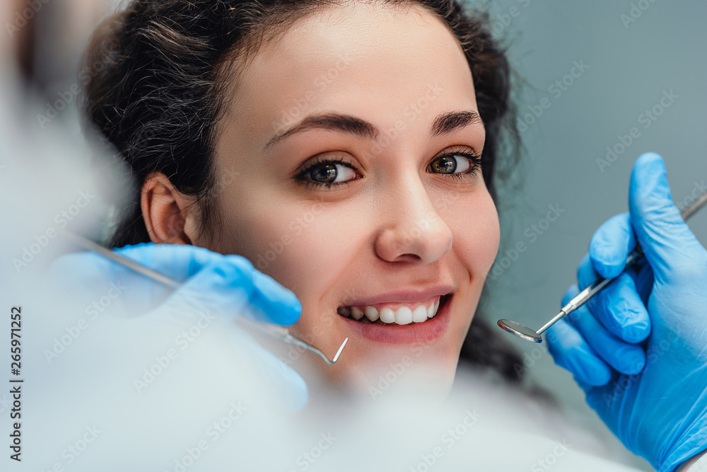 Smiling woman sitting in dentist chair ready for a dental check-up. Close up view. Smiling woman sitting in dentist chair ready for a dental check-up. Close up view.