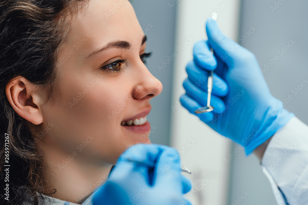 Dentist examining a patient's teeth in the dentist. Side view. Dentist examining a patient's teeth in the dentist. Side view.