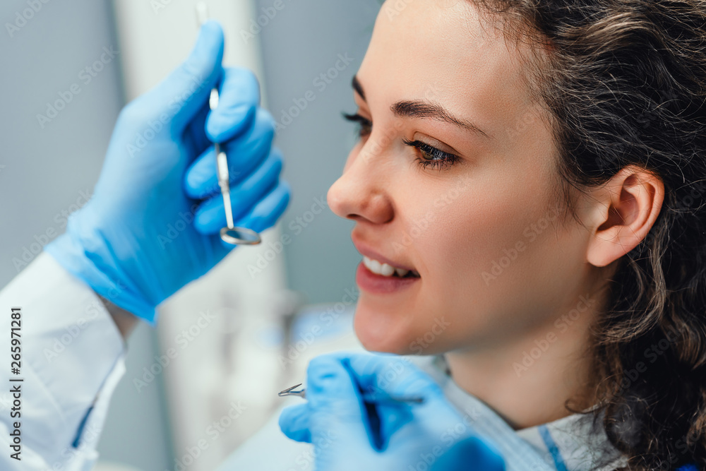 Dentist examines the oral cavity of a young patient on the dentist's chair. Side view. Close up view. Dentist examines the oral cavity of a young patient on the dentist's chair. Side view. Close up view.