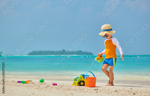 Three year old toddler playing on beach