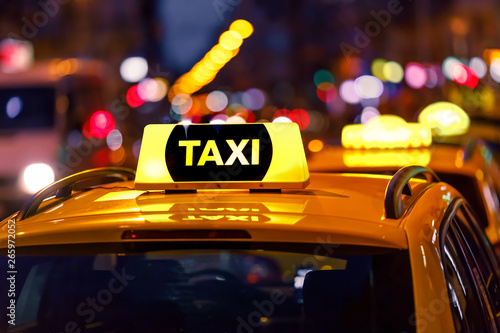 Yellow taxi cab and blurred city lights background at night with colorful bokeh