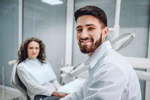 Portrait of a male dentist and young woman in a dentist office.