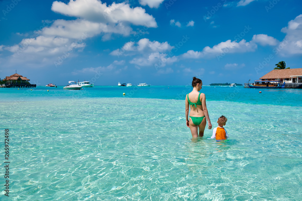 Toddler boy on beach with mother Toddler boy on beach with mother