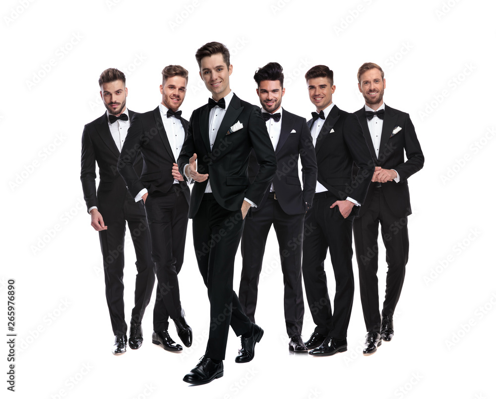 man in tuxedo pointing hand while walking besides his team man in tuxedo pointing hand while walking besides his team