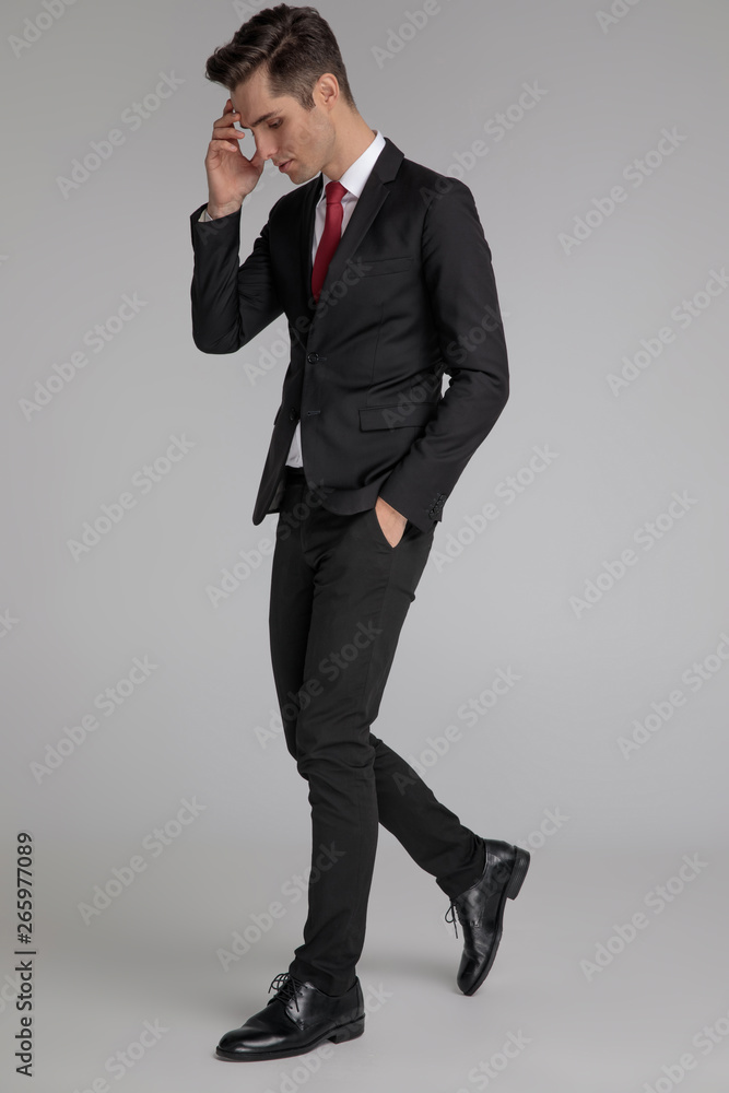 elegant man looking down with hand on forehead elegant man looking down with hand on forehead
