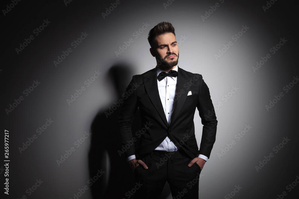 displeased man in black tuxedo standing with hands in pockets displeased man in black tuxedo standing with hands in pockets