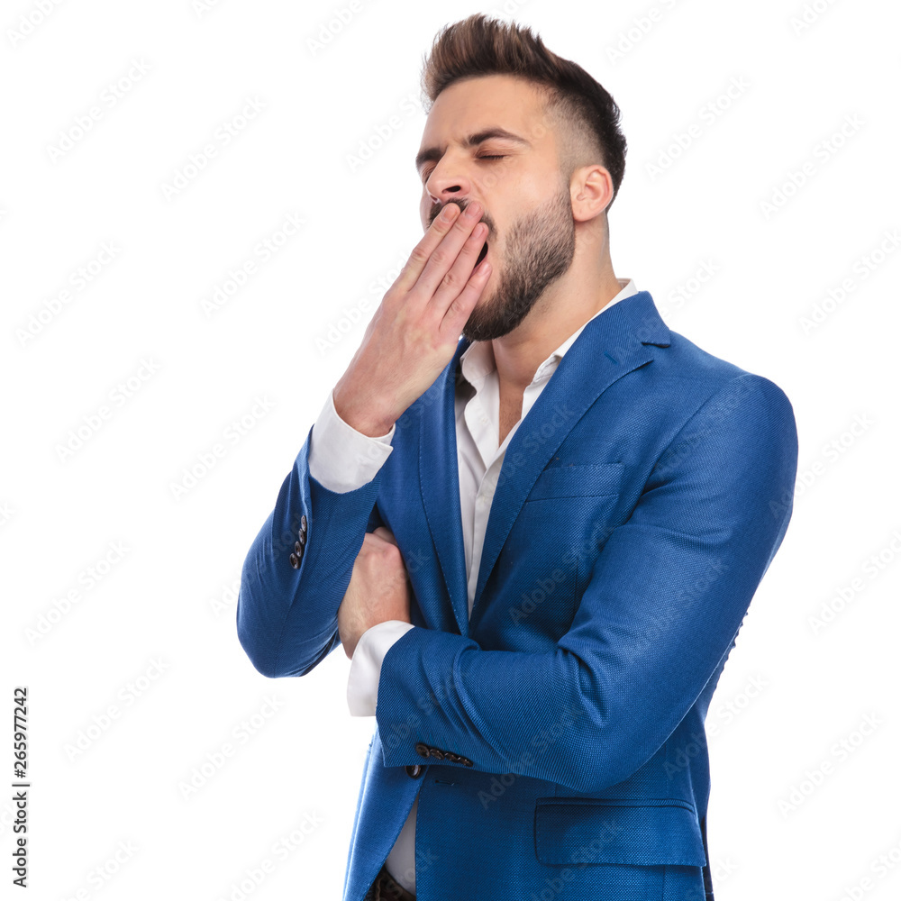 tired man in suit yawning with hand at mouth tired man in suit yawning with hand at mouth