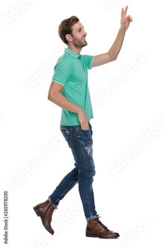 side view of a man walking while showing v sign