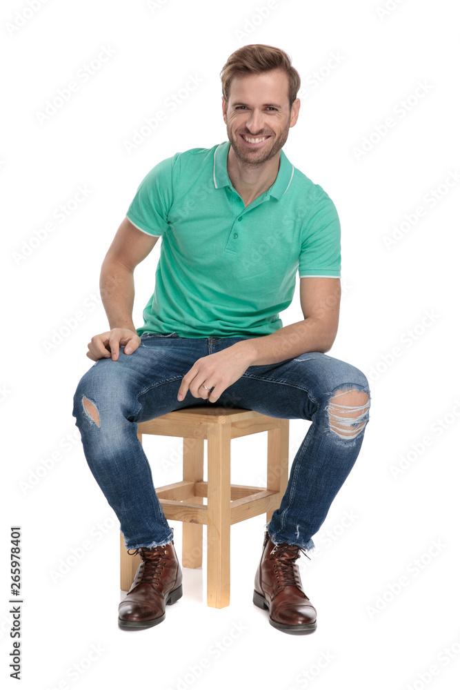 seated happy man resting his arm on leg seated happy man resting his arm on leg
