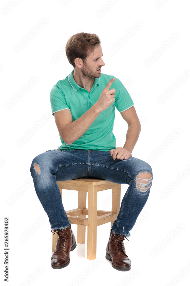 seated furious man making an observation with finger seated furious man making an observation with finger