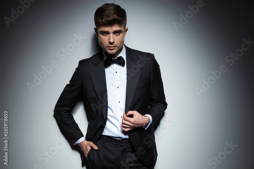 elegant man in black tuxedo holding hand in pocket