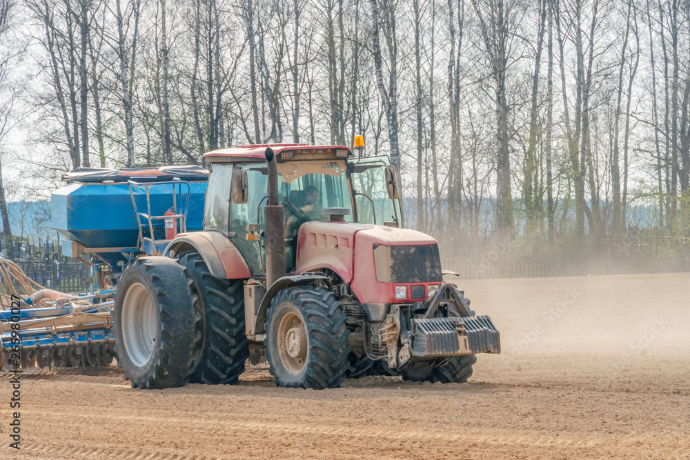 Farmer in tractor preparing land with seedbed cultivator as part of pre seeding activities in early spring season of agricultural works at farmlands. Farmer in tractor preparing land with seedbed cultivator as part of pre seeding activities in early spring season of agricultural works at farmlands.