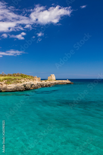 The important archaeological site and tourist resort of Roca Vecchia, Puglia, Salento, Italy. Turquoise sea, clear blue sky, rocks, sun, lush vegetation in summer. The sixteenth-century lookout tower