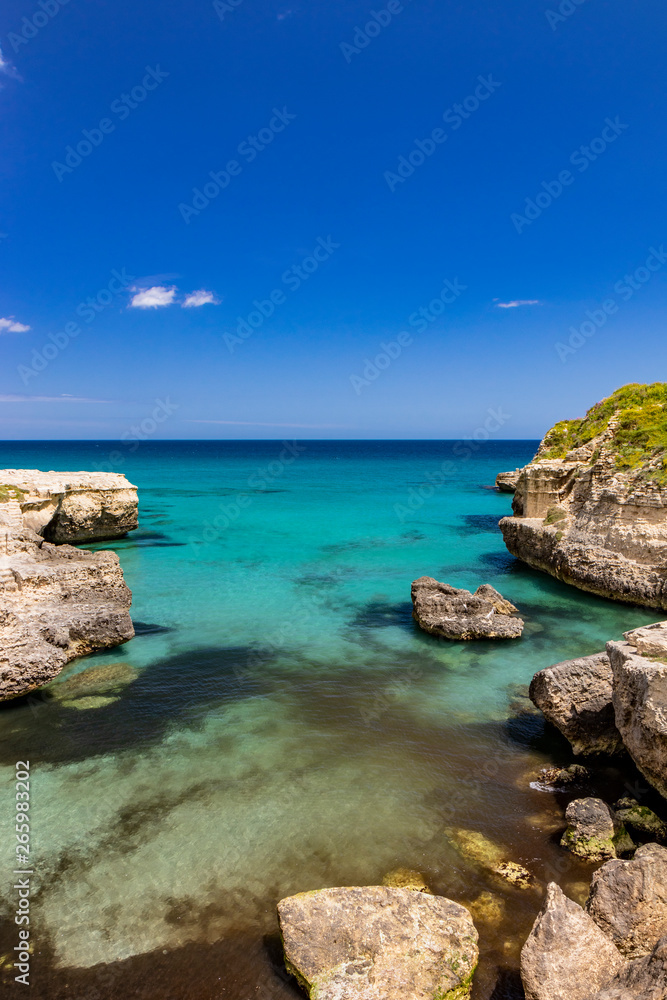 The important archaeological site and tourist resort of Roca Vecchia, in Puglia, Salento, Italy. Turquoise sea, clear blue sky, rocks, sun, lush vegetation in summer. Messapic Walls.