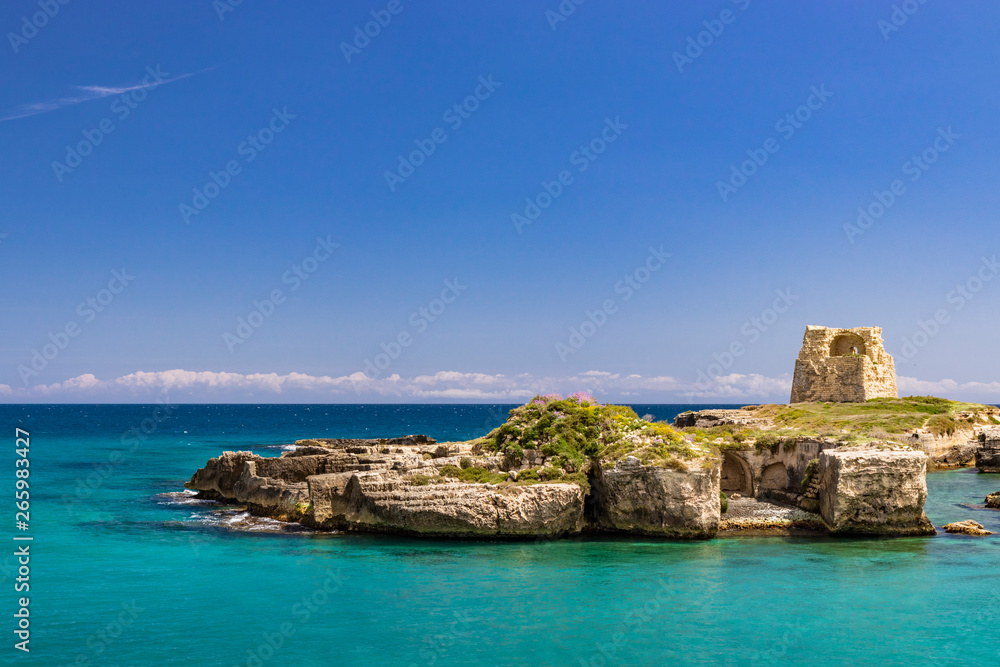 The important archaeological site and tourist resort of Roca Vecchia, in Puglia, Salento, Italy. Turquoise sea, clear blue sky, rocks, sun, in summer. Messapic walls and ruins of the watch tower