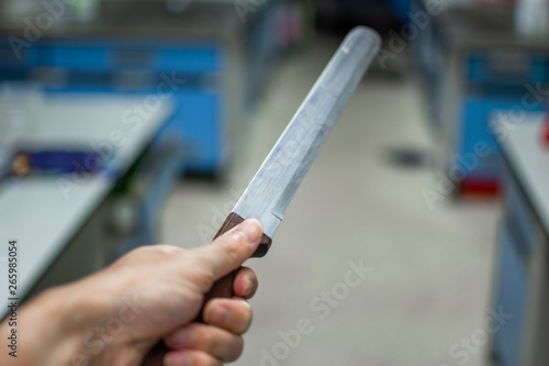 Hand holding an knife on blurred background. decoration image contain certain grain and noise.