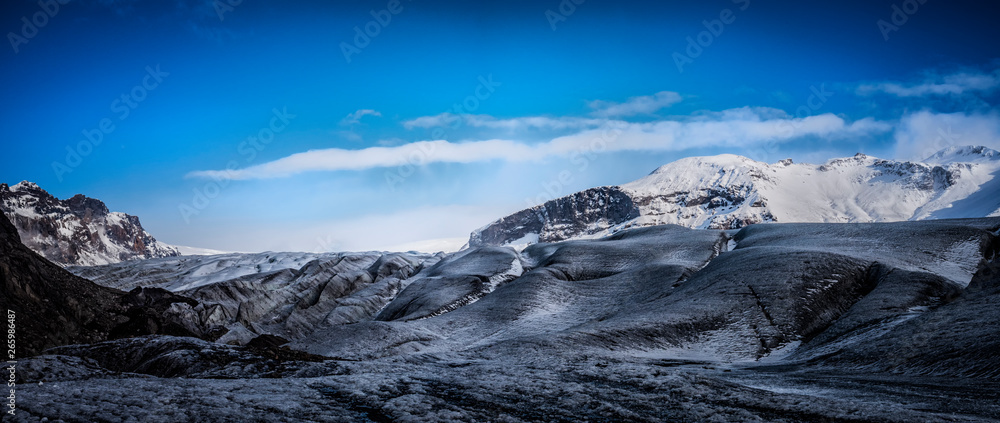 Obraz premium Huge majestic glacier's icy surface by snowy mountain in Iceland
