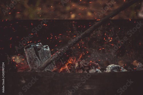 charcoal smolder in the iron grill. cooking picnic outdoors. sparks over the embers top view close up