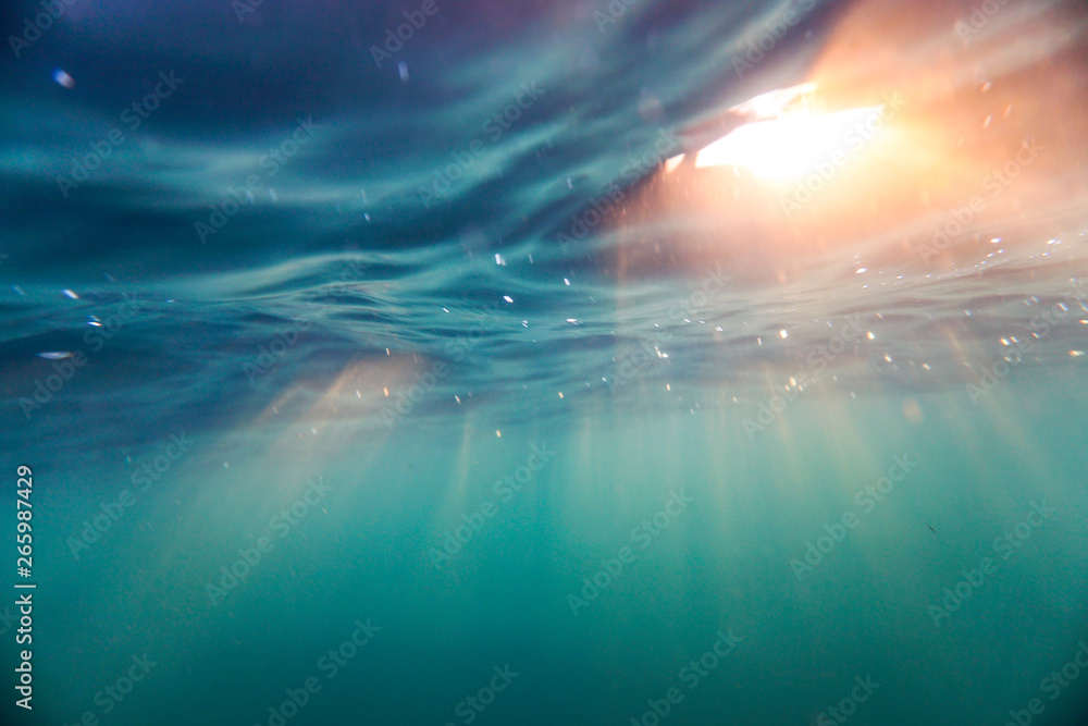 Bright beams of sunlight refracting through the surface of the atlantic ocean. - obrazy, fototapety, plakaty 