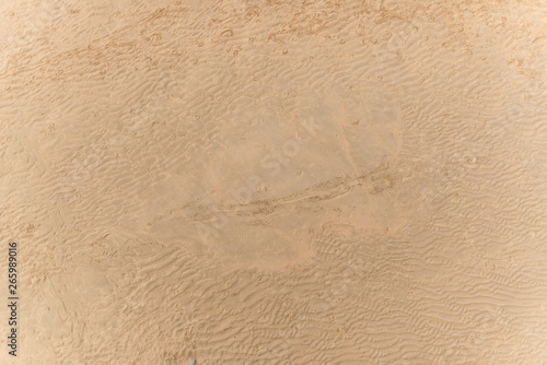 Sandy beach with footprints seen from above. photo