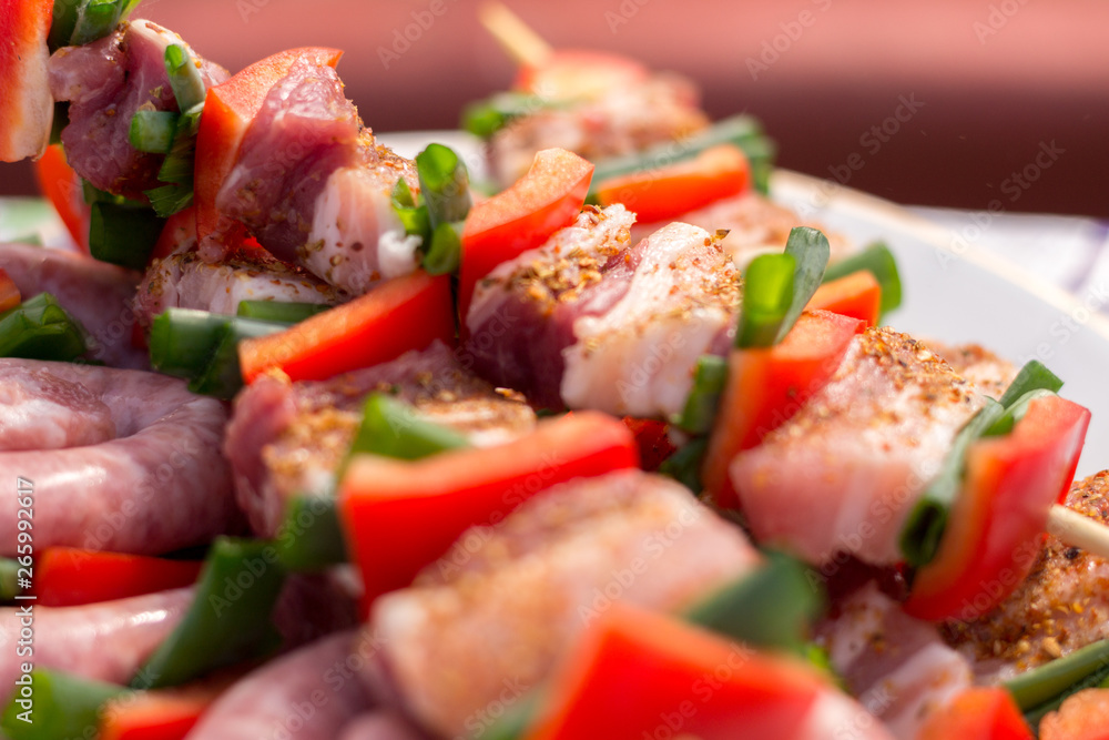 Close up pf delicious chicken breast on wooden skew with fresh vegetables, garlic, paprika fried on mangal barbeque grill and smoke Close up pf delicious chicken breast on wooden skew with fresh vegetables, garlic, paprika fried on mangal barbeque grill and smoke