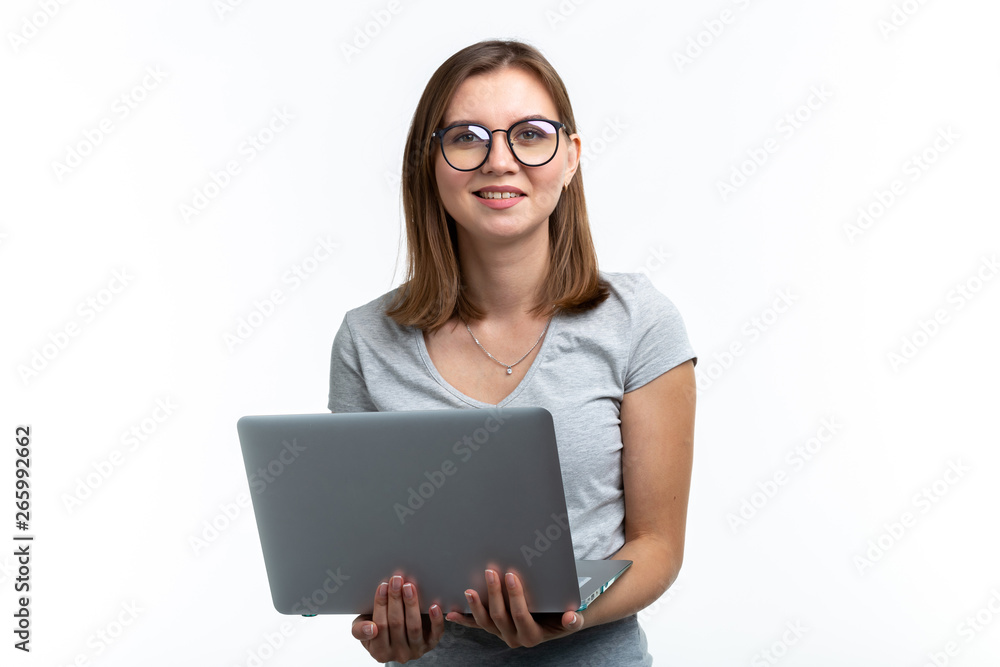 People and education concept - Attractive student woman holding a laptop over white background People and education concept - Attractive student woman holding a laptop over white background