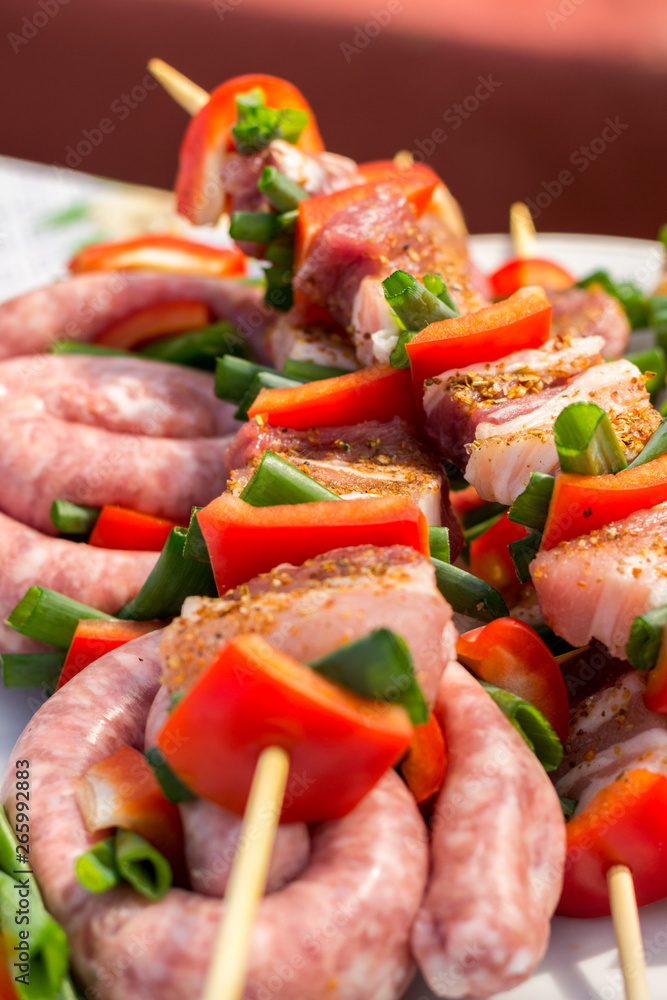 Close up pf delicious chicken breast on wooden skew with fresh vegetables, garlic, paprika fried on mangal barbeque grill and smoke Close up pf delicious chicken breast on wooden skew with fresh vegetables, garlic, paprika fried on mangal barbeque grill and smoke