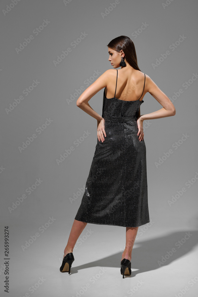 Young fashion woman in cocktail dress with sequins. Dark hair, posing in studio Young fashion woman in cocktail dress with sequins. Dark hair, posing in studio