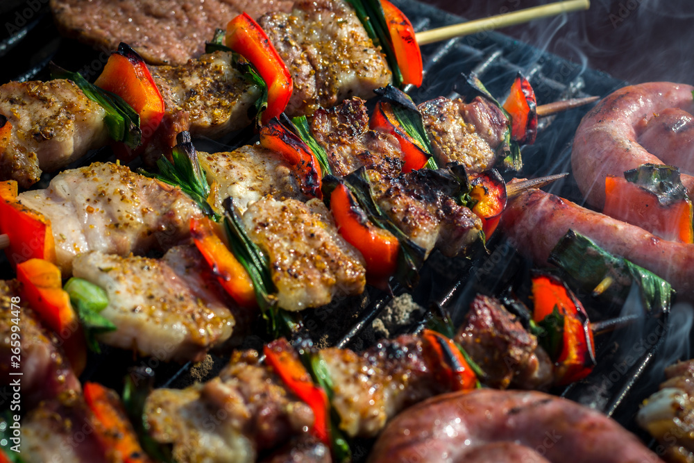 Close up pf delicious chicken breast on wooden skew with fresh vegetables, garlic, paprika fried on mangal barbeque grill and smoke Close up pf delicious chicken breast on wooden skew with fresh vegetables, garlic, paprika fried on mangal barbeque grill and smoke