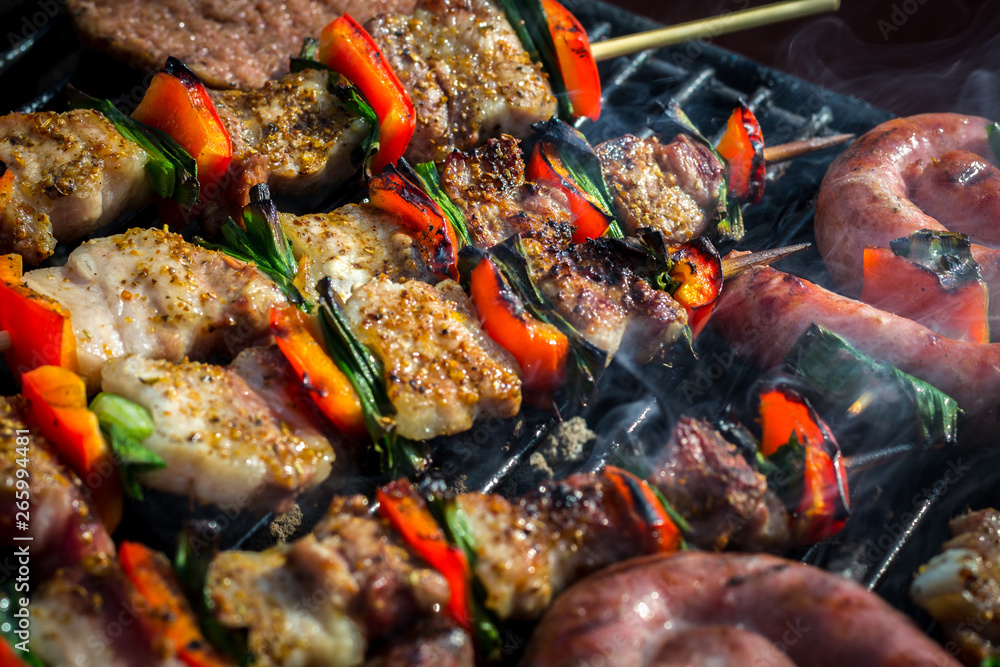 Close up pf delicious chicken breast on wooden skew with fresh vegetables, garlic, paprika fried on mangal barbeque grill and smoke Close up pf delicious chicken breast on wooden skew with fresh vegetables, garlic, paprika fried on mangal barbeque grill and smoke