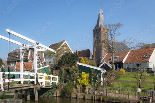 View of the Maxima drawbridge, wooden houses and protestant church tower in the village of Marken, Netherlands