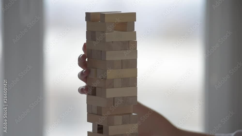 Closeup photo of child playing wooden blocks tower game Closeup photo of child playing wooden blocks tower game