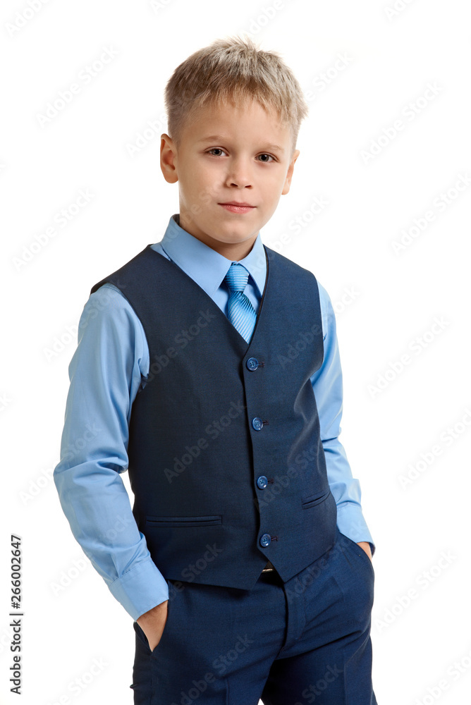 Smiling blond boy in school uniform holding hands in pockets Smiling blond boy in school uniform holding hands in pockets