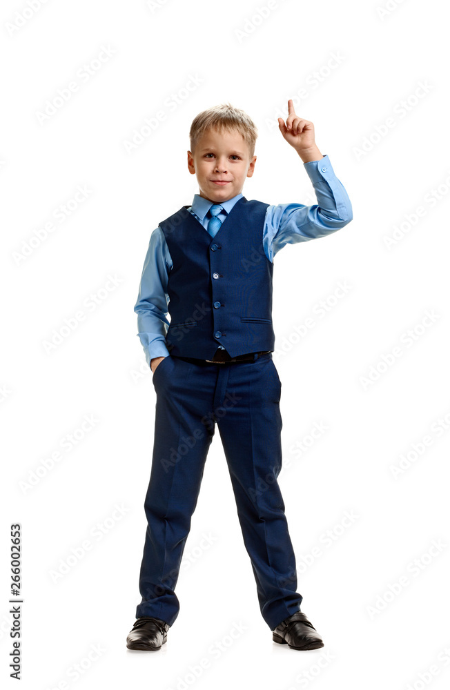 Full portrait of smart boy in school uniform showing raised finger Full portrait of smart boy in school uniform showing raised finger