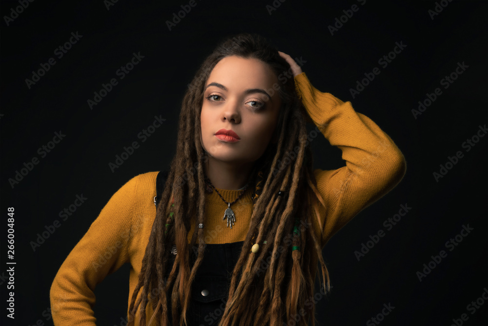 Portrait of a young girl with dreads on black background. Studio shoot. Portrait of a young girl with dreads on black background. Studio shoot.