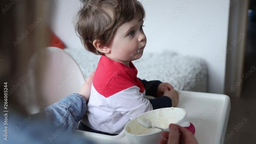 little toddler boy sitting in chair during lunch at home. little toddler boy sitting in chair during lunch at home.