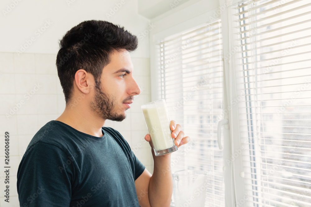 A young man prepared himself for breakfast a smoothie of vegetable milk and fresh fruit. He leads a healthy lifestyle. A young man prepared himself for breakfast a smoothie of vegetable milk and fresh fruit. He leads a healthy lifestyle.