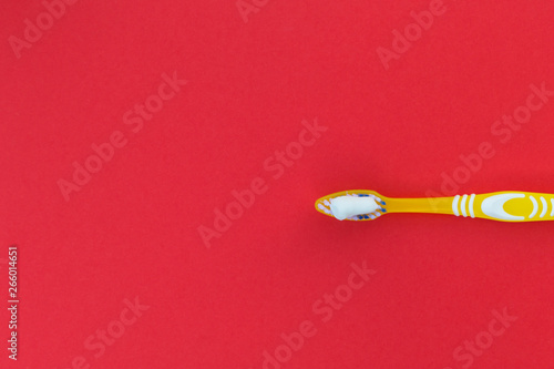 Toothbrush and toothpaste on a red background.