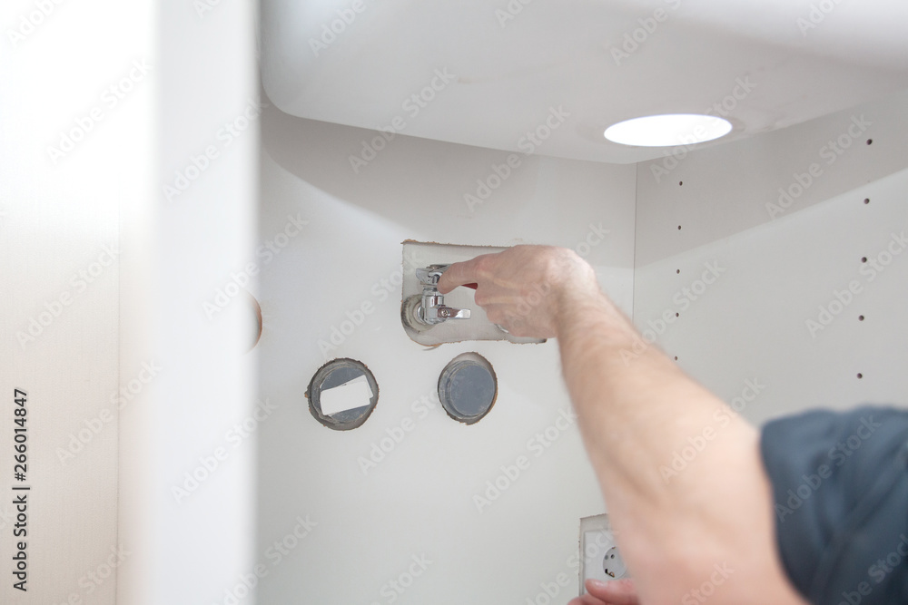 Naklejka premium Repair in bathroom at home. Plumber installing and setting new mixer tap. Hands worker close up. Outflow leakage.