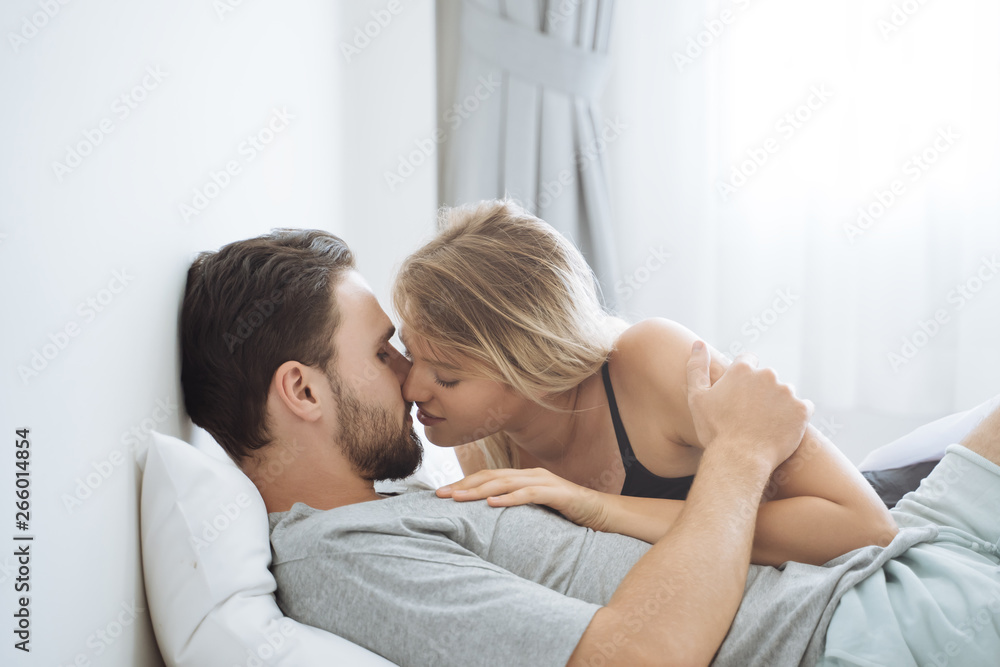 Young couple kissing in the bed .loving couple in bedroom Young couple kissing in the bed .loving couple in bedroom